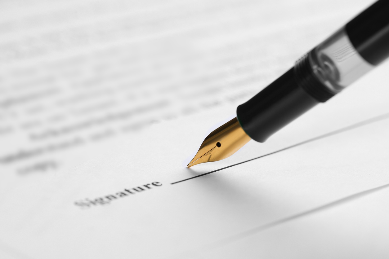 A pen resting on the signature line of a fee division agreement